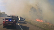 A dash camera still image provided by the Lake City Police department shows emergency vehicles, the suspect’s white car, an nearby grass ablaze following a chase on Highway 61.